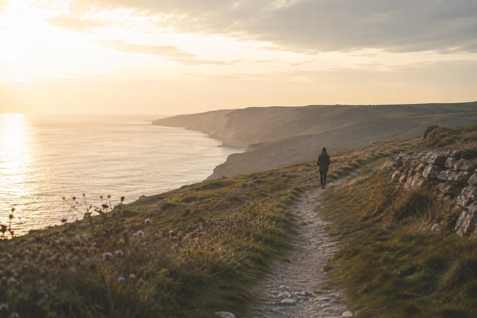 A person walking along an open coastline